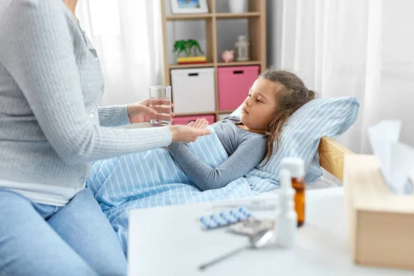 Mother giving medicine to sick little daughter — Stock Photo, Image