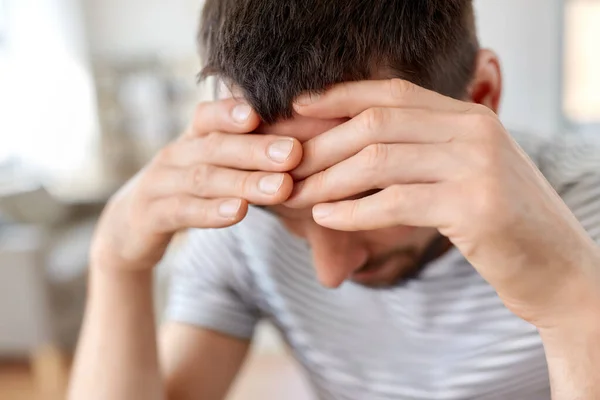 Primer plano del hombre estresado que tiene dolor de cabeza en casa — Foto de Stock