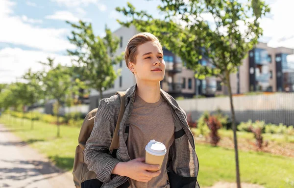 Jovem com mochila bebendo café na cidade — Fotografia de Stock