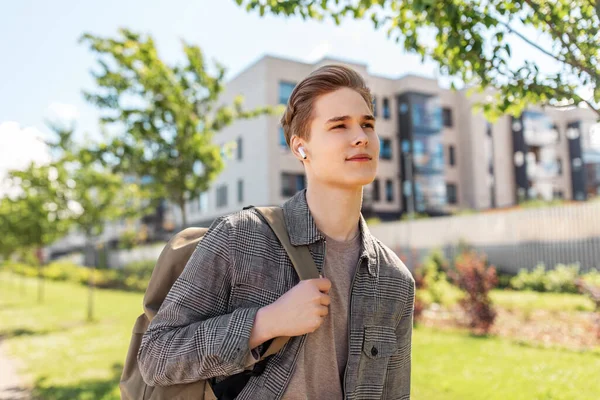 Νεαρός άνδρας με ακουστικά και σακίδιο πλάτης στην πόλη — Φωτογραφία Αρχείου