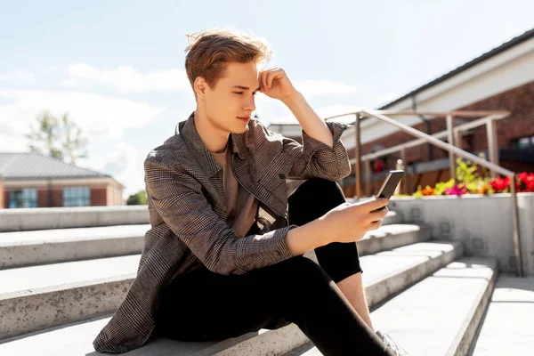 Хлопчик-підліток використовує смартфон у місті — стокове фото