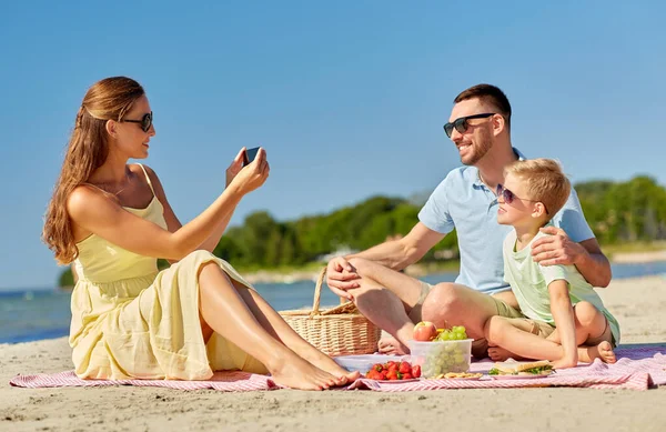 Rodzina ze smartfonem fotografującym na plaży — Zdjęcie stockowe