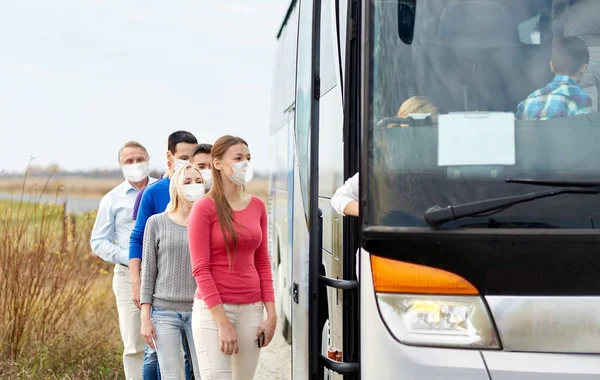 Ομάδα επιβατών με μάσκες επιβίβαση σε ταξιδιωτικό λεωφορείο — Φωτογραφία Αρχείου