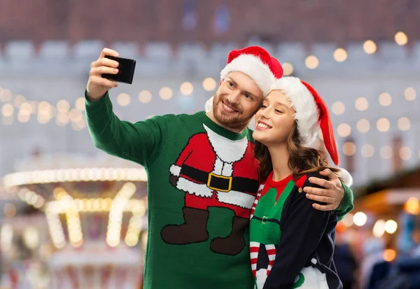 Gelukkig paar in kerst truien het nemen van selfie — Stockfoto