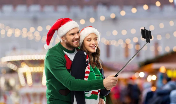 Felice coppia in maglioni di Natale prendendo selfie — Foto Stock