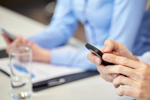 Manos con el teléfono inteligente en la oficina — Foto de Stock