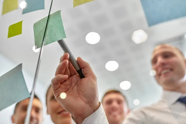 Geschäftsteam mit klebrigen Zetteln auf Glas im Büro — Stockfoto