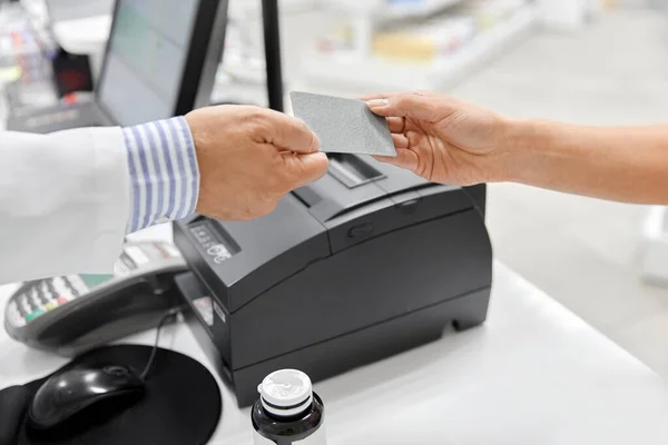 Primer plano de la mano dando tarjeta bancaria al farmacéutico — Foto de Stock