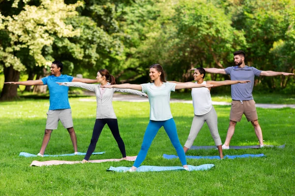 Grupo de pessoas fazendo ioga no parque de verão — Fotografia de Stock