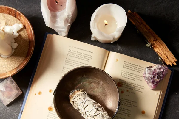 Libro magico, salvia, candele accese e bastone rituale — Foto Stock