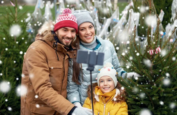 Familia tomando selfie con árbol de Navidad en el mercado —  Fotos de Stock