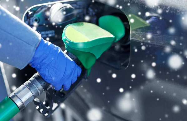 Close up of hand in glove filling car with petrol — Stock Photo, Image