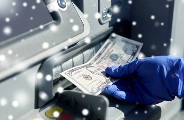 Hand in medical glove with money at atm machine — Stock Photo, Image