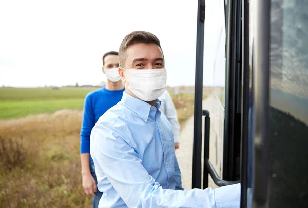 Group of passengers in masks boarding travel bus — Stock Photo, Image