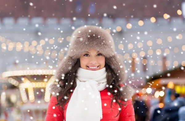 Glad kvinna i vinter hatt över jul marknaden — Stockfoto