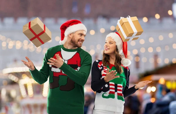 Casal feliz em camisolas de Natal com presentes — Fotografia de Stock