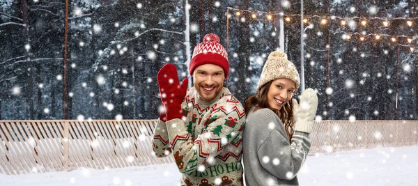 Couple en pull laid sur la patinoire de Noël — Photo