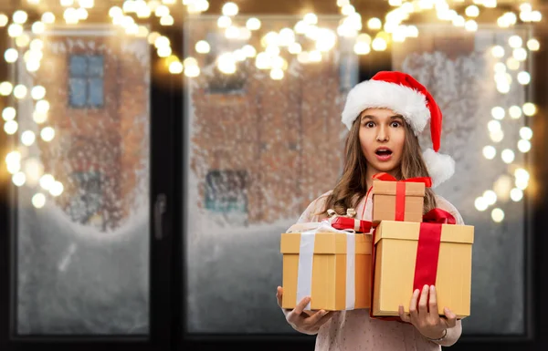 Tiener meisje in santa hoed met kerst cadeau — Stockfoto