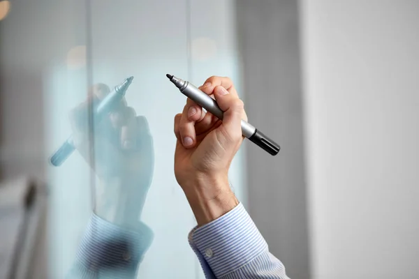 Hand with marker and sticker on glass at office — Stock Photo, Image