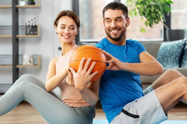 Feliz pareja haciendo ejercicio con la pelota en casa —  Fotos de Stock