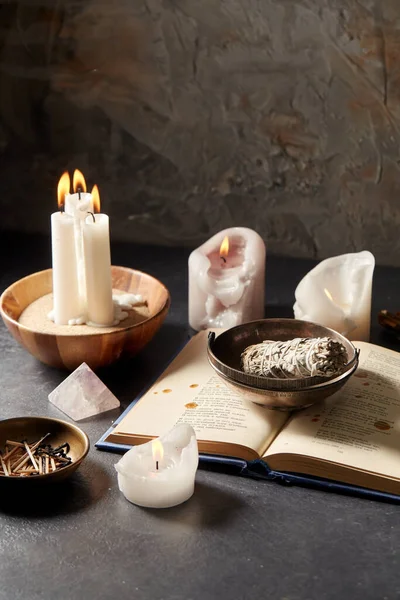 Magic book, sage, burning candles and ritual staff — Stock Photo, Image