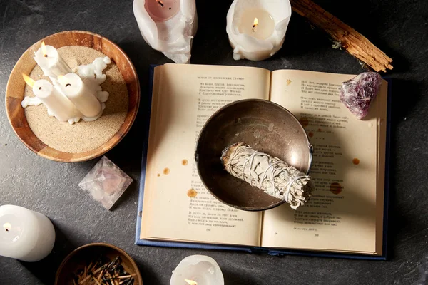 Волшебная книга, мудрец, горящие свечи и ритуальный посох — стоковое фото