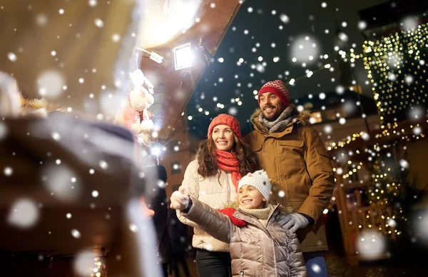 Šťastná rodina na vánočním trhu ve městě — Stock fotografie