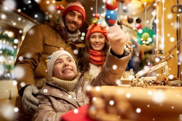 Lycklig familj köper souvenirer på julmarknaden — Stockfoto