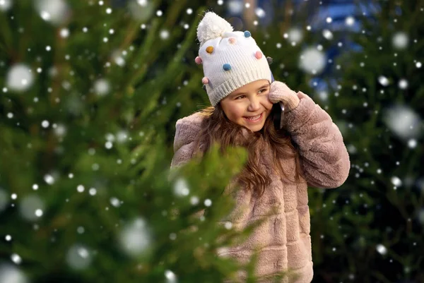 女孩在圣诞树上用智能手机打电话 — 图库照片