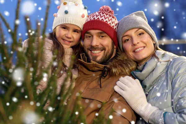 Feliz familia eligiendo el árbol de Navidad en el mercado — Foto de Stock