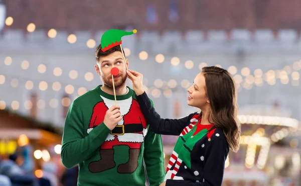 Couple with christmas party props in ugly sweaters — Stock Photo, Image