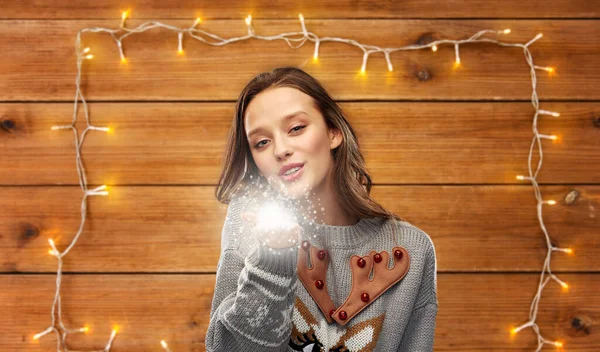 Mujer en suéter de Navidad feo con polvo mágico — Foto de Stock