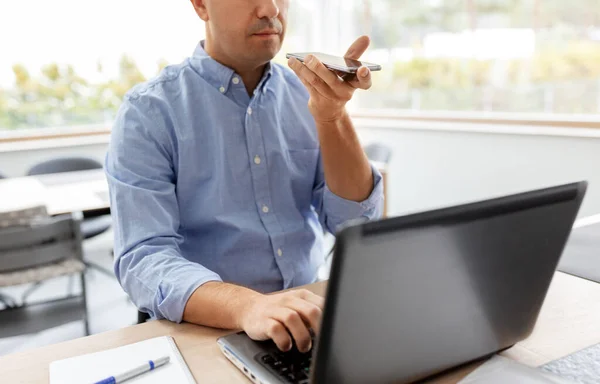 Homme avec smartphone et ordinateur portable au bureau à domicile — Photo