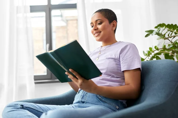 Mujer afroamericana feliz leyendo libro en casa — Foto de Stock