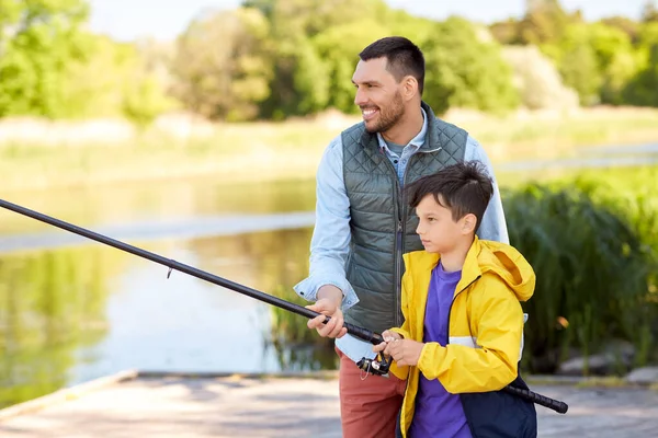 Gelukkig lachende vader en zoon vissen op de rivier — Stockfoto
