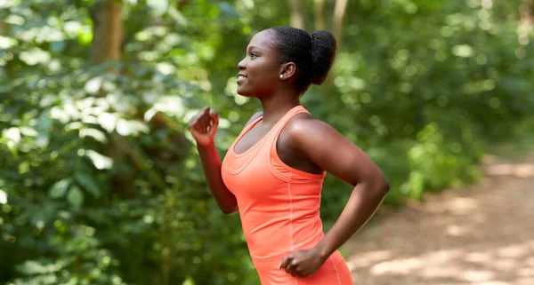 Junge Afroamerikanerin läuft in Wald — Stockfoto