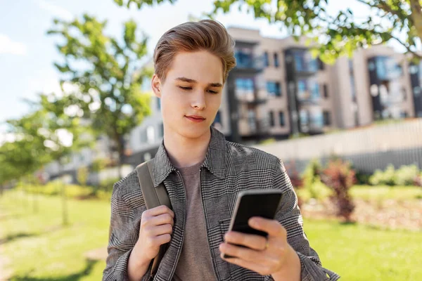 Підлітковий студентський хлопчик з телефоном і сумкою в місті — стокове фото