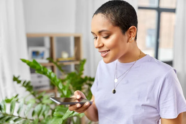 Afro-américaine avec smartphone à la maison Photos De Stock Libres De Droits