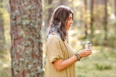 woman or witch performing magic ritual in forest clipart