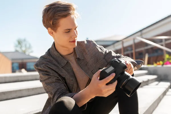 Mladý muž s fotoaparátem fotografování ve městě — Stock fotografie