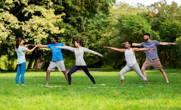 Groep mensen die yoga doen in het zomerpark — Stockfoto