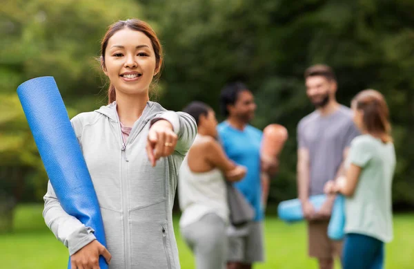 Mujer con esterilla de yoga apuntando con el dedo a la cámara — Foto de Stock