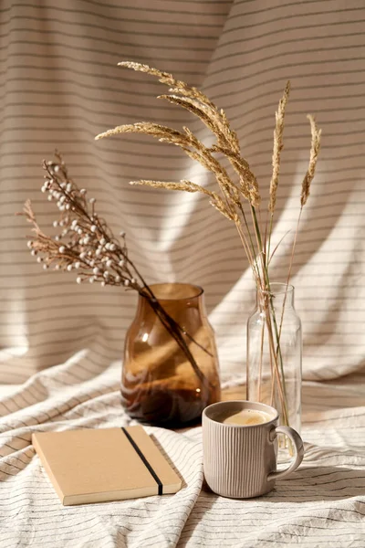 Чашка кофе, дневник и сушеные цветы в вазах — стоковое фото