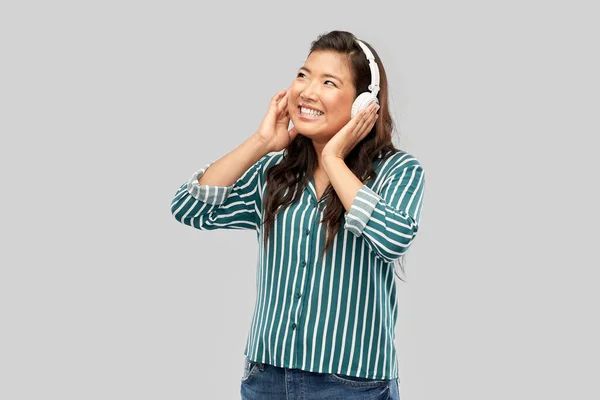 Asian woman in headphones listening to music — Stock Photo, Image