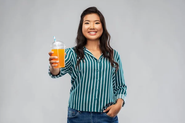 Asiatisk kvinna med saft i plastmugg med halm — Stockfoto
