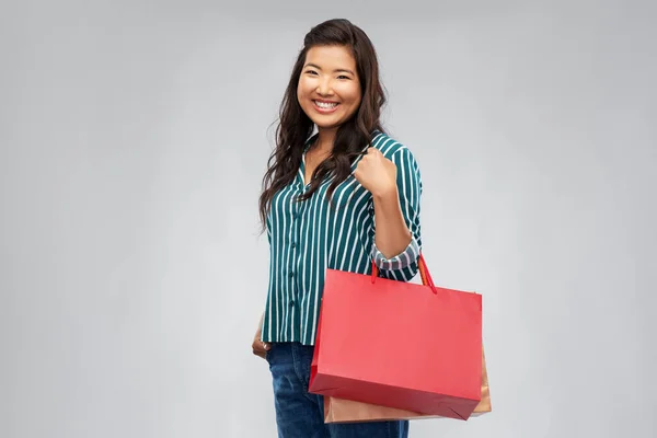 Gelukkig aziatische vrouw met winkelen tassen — Stockfoto