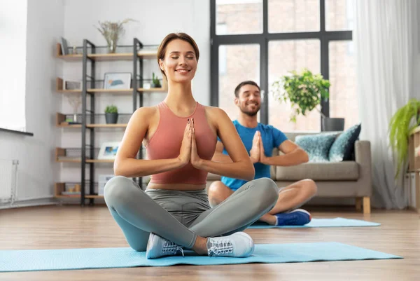 Feliz pareja meditando en yoga pose de loto en casa — Foto de Stock