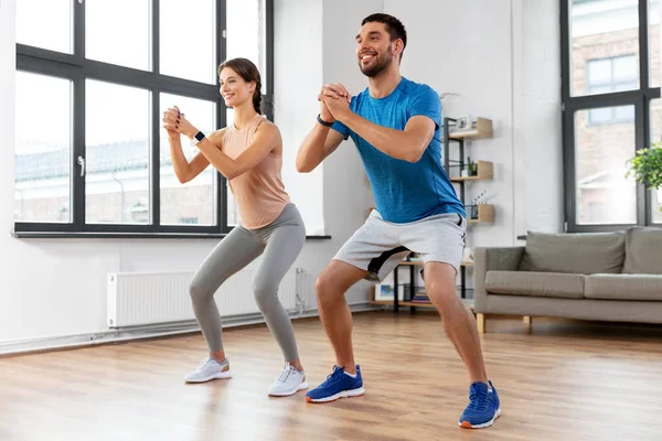 Gelukkig paar oefenen en doen hurken thuis — Stockfoto