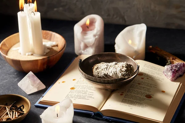 stock image magic book, sage, burning candles and ritual staff