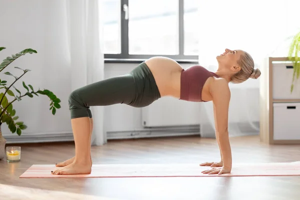 Mujer embarazada feliz haciendo yoga en casa —  Fotos de Stock